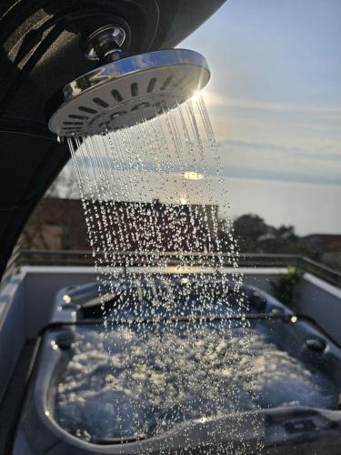 a shower with water coming out of it at Apartman Štorija in Brela