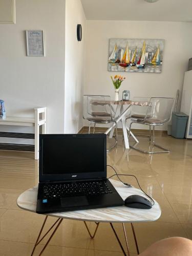 a laptop computer sitting on a table in a living room at Tessitura Murter apartman in Murter
