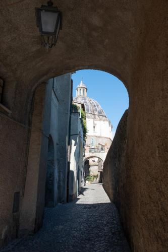 a view of a building through an arch in a street at appartamento LE LOGGE in Montefiascone