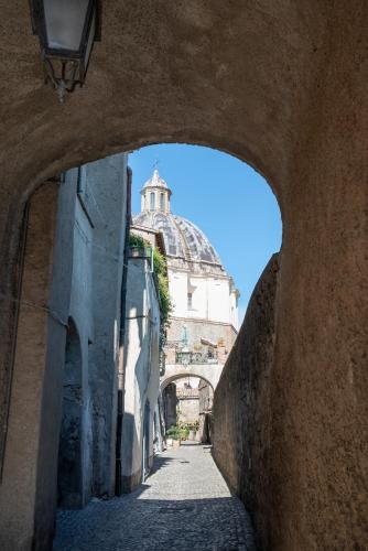 a view of a building through an arch in a street at appartamento LE LOGGE in Montefiascone