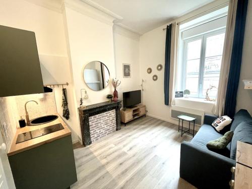 un salon avec un canapé bleu et une cheminée dans l'établissement Studio Cosy La Chouette, à Dijon