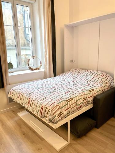 un lit assis dans une pièce avec une fenêtre dans l'établissement Studio Cosy La Chouette, à Dijon