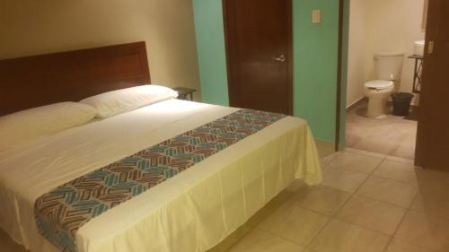 a bedroom with a bed and a bathroom with a toilet at Villas y Suites 304 in Tampico