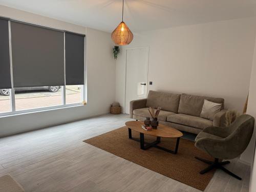a living room with a couch and a table at Smile home 3 Wormerveer- Zaanse Schans en Amsterdam appartements in Wormerveer