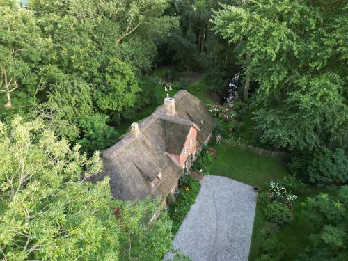 Φωτογραφία από το άλμπουμ του Dachgeschosswohnung Warft Simmerdeis in Reetdachhaus mit parkähnlichem Garten σε Oldenswort