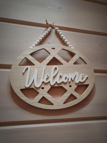 a welcome sign hanging on a wooden wall at Le petit chalet de campagne in Richeling