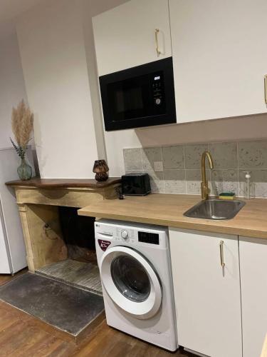 a kitchen with a washing machine and a sink at Appt RDC meublé 2 ou 4 pers in Blagny