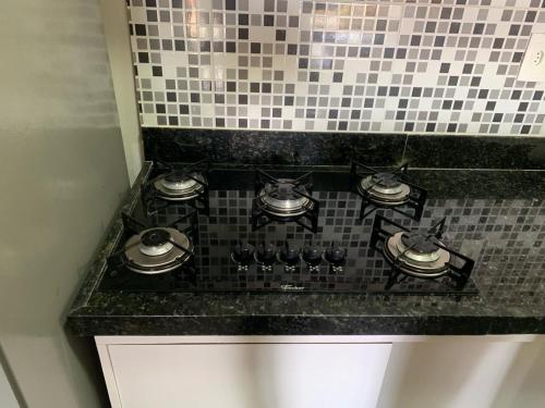 una cucina con piano cottura e parete piastrellata di Gavoa Resort Flat 108 E a Igarassu