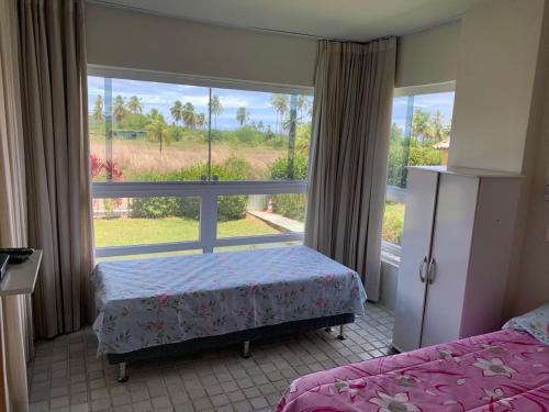 una camera da letto con due letti e una grande finestra di Gavoa Resort Flat 108 E a Igarassu