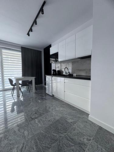 eine Küche mit weißen Schränken, einem Tisch und einem Esszimmer in der Unterkunft NEW -Sweet Dreams -Na uboczu Centrum -PARKOWE WZGÓRZE -Garaż Podziemny-f VAT in Kielce