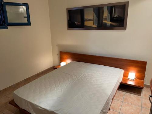 una camera da letto con un letto bianco con due luci sopra di VERDE BLUE 313 Barbati a Barbati