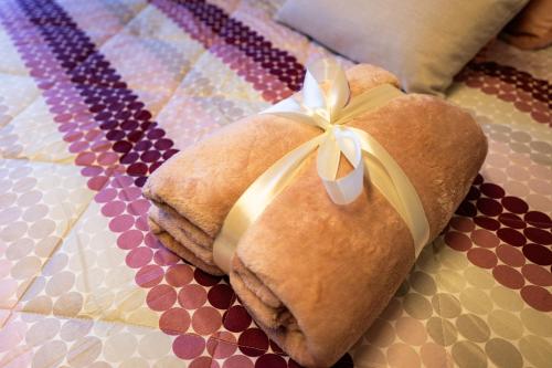 a teddy bear with a bow on a quilt at Torre dei Venti in Ceccano