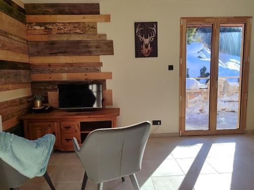 d'un salon avec une télévision et une porte coulissante en verre. dans l'établissement Gîte Le Polonate, aux Contamines-Montjoie