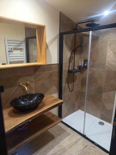 La salle de bains est pourvue d'une douche et d'un lavabo noir. dans l'établissement Gîte Le Polonate, aux Contamines-Montjoie
