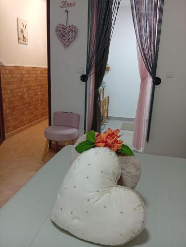 a heart shaped pillow on a bed in a room at Les Bromélias chez Djo et Rosy in Sainte-Marie