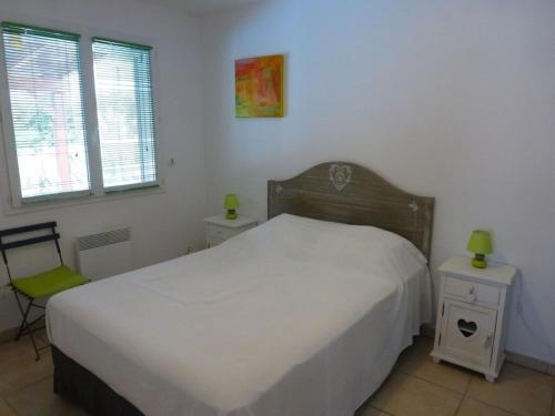 - une chambre avec un lit, 2 tables de nuit et 2 fenêtres dans l'établissement Villa l Olivier avec piscine privée, à Les Cluses