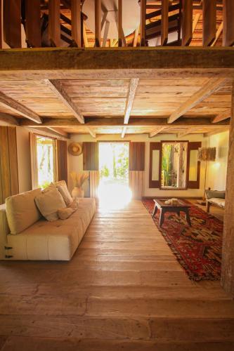 a living room with a couch in the middle of a room at Pousada Quinta de Caraíva in Porto Seguro