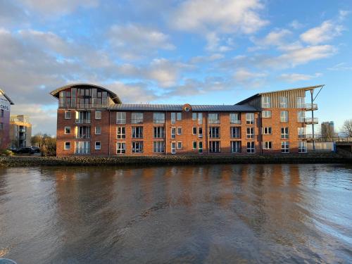 un grande edificio in mattoni accanto a un fiume di Simmerdeis am Hafen a Husum