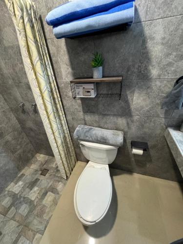 a bathroom with a toilet and a blue towel at Departamentos Ramos Arizpe Saltillo Facturable in Ramos Arizpe