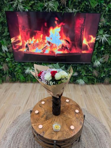 a vase of flowers on a table in front of a fireplace at F & C Love Spa, Sauna and Tantra in Chartrettes