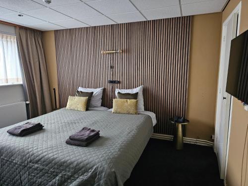 a hotel room with a bed with two pillows on it at Hotel Restaurant Solskin in Vlissingen