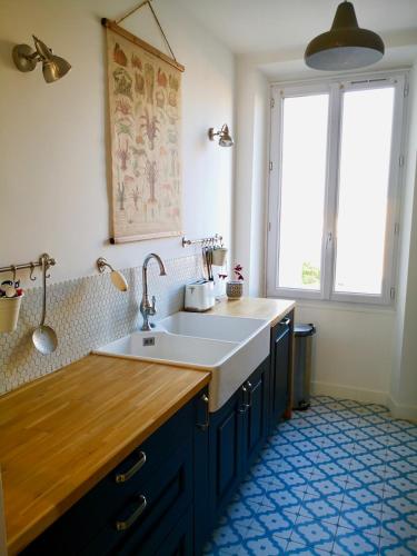 une cuisine avec un évier et une grande fenêtre dans l'établissement Casa Cheppio Appartement cœur Antibes, à Antibes