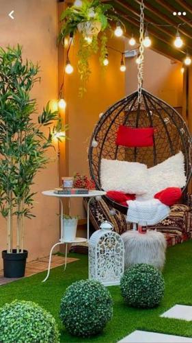 a room with a rattan chair with red and white pillows at The European House Pattaya in North Pattaya