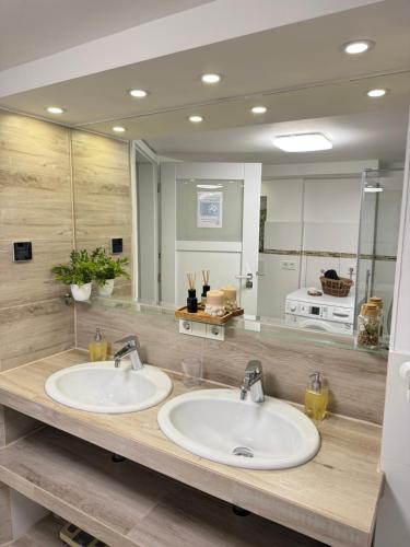 a bathroom with two sinks and a large mirror at Family & Friends Hannover 75m2, Messe in Hannover