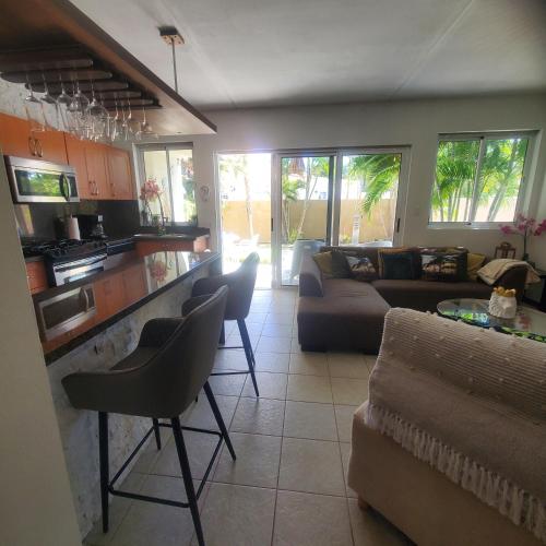 a kitchen and living room with a couch and chairs at Bohemian Townhouse Palm Beach Aruba in Palm-Eagle Beach