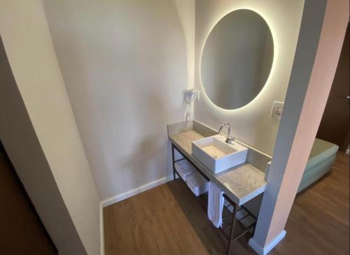a bathroom with a sink and a mirror at Hot Beach Suites in Olímpia