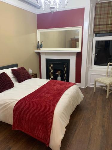 a bedroom with a large bed and a fireplace at An Cuilidh in Port Bannatyne