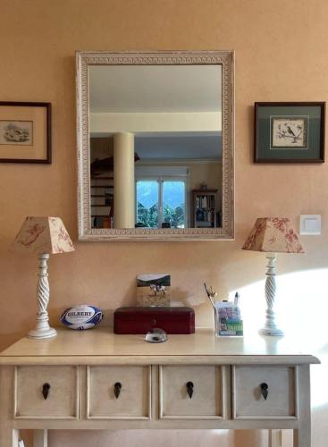 - une commode avec deux lampes et un miroir dans l'établissement Maison agréable et lumineuse, jardin vue nature, Nant Aveyron, à Nant