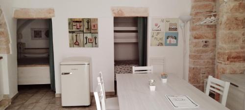 eine Küche mit Tisch und Kühlschrank in der Unterkunft Trulli Almadè in Alberobello