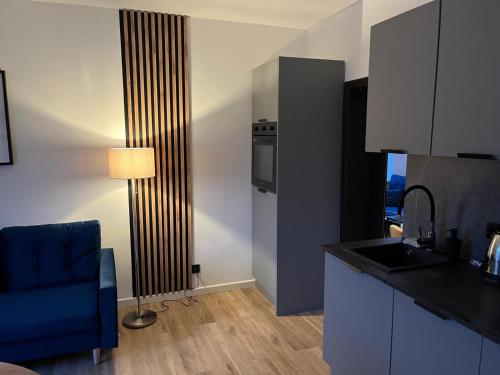 a kitchen with a sink and a blue chair in a room at W Izerach - Apartament Superior in Szklarska Poręba