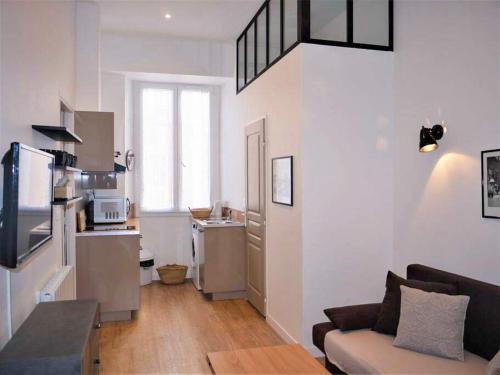 un salon avec un canapé et une cuisine dans l'établissement Barla 1 - a cosy one bedroom apartment in Nice, à Nice