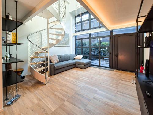a living room with a spiral staircase and a couch at Modern loft, design & comfort in Milan