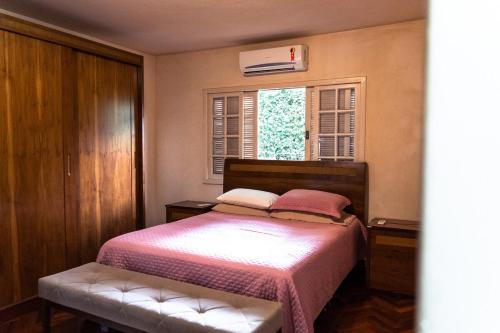 a bedroom with a bed and a window at Casa Mirante da Serra em Tiradentes - MG in Tiradentes