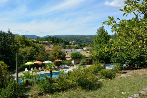 a resort with a swimming pool with umbrellas at Manoir de Champvert in Les Vans