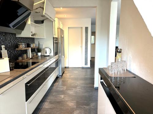 a kitchen with a counter with wine glasses on it at Ruhe Oase Steinhöfel - Balkon, Naturblick, Design-Maisonette-Apartment - nahe Fürstenwalde-Spree in Steinhöfel