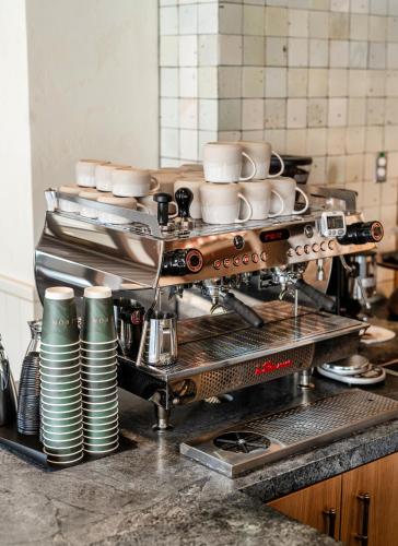 a coffee machine in a kitchen with cups and plates at Hotel Heron Old Town Alexandria in Alexandria