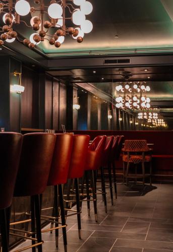 a row of chairs in a restaurant with a bar at Hotel Heron Old Town Alexandria in Alexandria