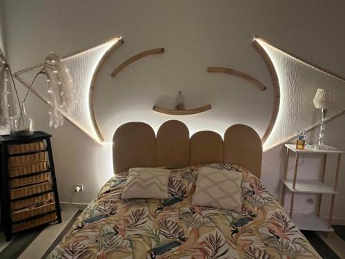 a bedroom with a bed with a weird headboard at super T3 - Hypercentre Angers Ralliement in Angers
