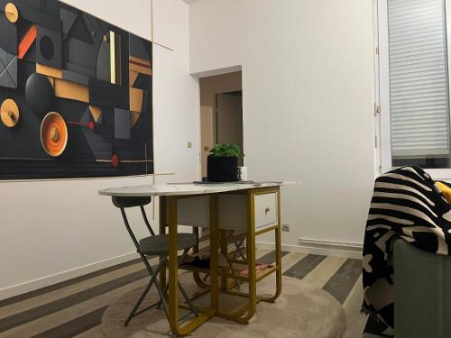 a table in a room with a painting on the wall at super T3 - Hypercentre Angers Ralliement in Angers