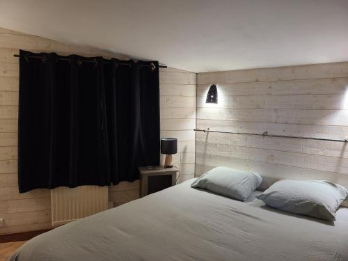 a bedroom with a bed and a black curtain at Les pléiades in Lamballe Armor