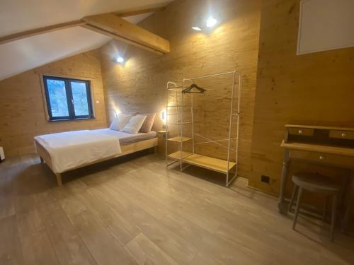 a bedroom with a bed and a glass shower at Chalet muguet & Jaccuzi privatif in Rochesson