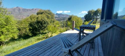 a bench sitting on the deck of a house at Cabañas Bella vista Ruca hue in San Martín de los Andes