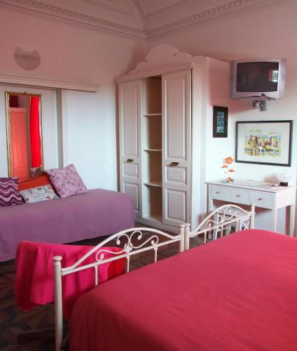 a bedroom with two beds and a desk and a tv at B&B Bianca in Catania