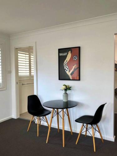 a dining room with a table and two chairs at Family Getaway With LARGE Parent Retreat! in Shellharbour