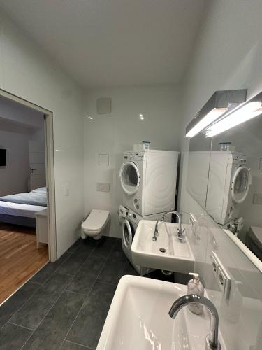 a bathroom with a sink and a washing machine at Al Nafurah Apartments in Munich