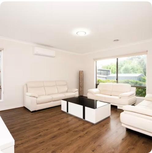 a living room with two white couches and a table at hayes getaway in Rosebud